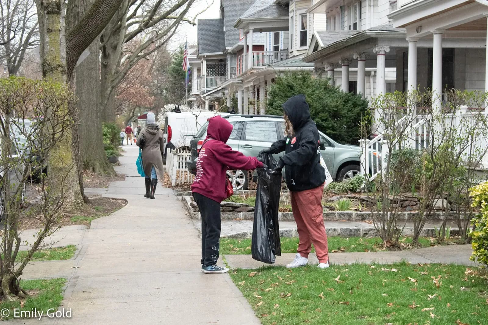 Neighbors sweeping a sidewalk during a DPWNA cleanup